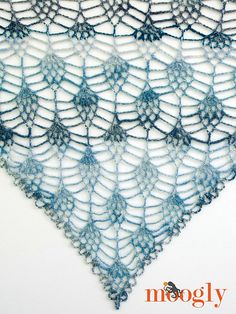 a blue crocheted shawl is shown with the words moogly written on it