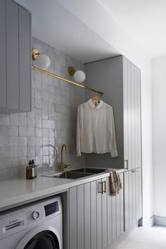 a washer and dryer in a small room next to a wall mounted washing machine