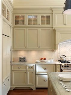 a kitchen filled with lots of white cabinets and counter top space next to an oven