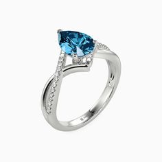 a white gold ring with blue topaz and diamonds on the sides, set in 18k white gold