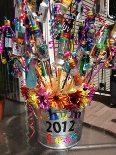 a bucket filled with lots of bottles and confetti on top of a table