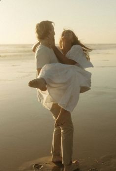 two women standing on the beach holding each other