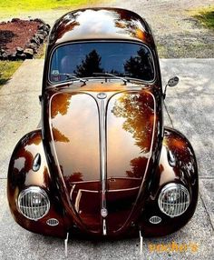 the front end of an antique car parked in a driveway