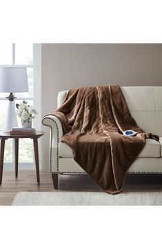 a white couch with a brown blanket on it