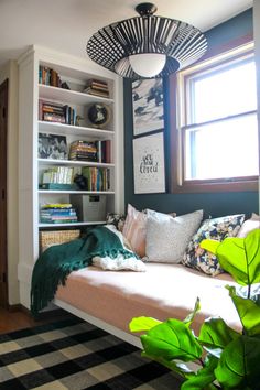 a living room filled with lots of furniture and bookshelves next to a window