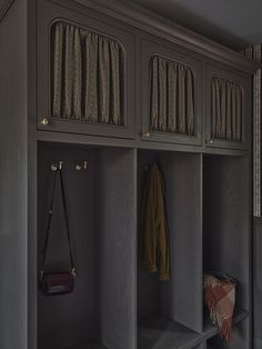 a coat rack with two coats hanging from it's sides and a purse on the other side