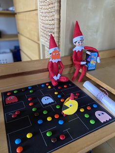 two elfs are playing an interactive game on the table with pac - man toys