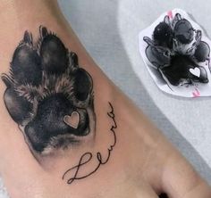 a tattoo on the foot of a person with a dog paw