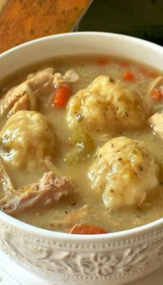 a white bowl filled with meat and dumplings