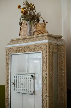 a white cabinet with flowers and a basket on top