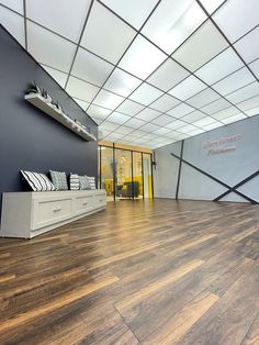 an empty room with wood flooring and walls painted blue, white and grey colors