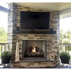 an outdoor fireplace with a flat screen tv above it