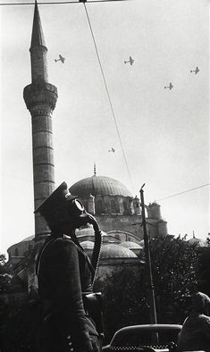 an old black and white photo of a man in front of a mosque