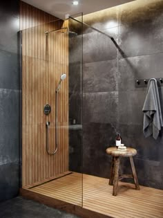 a walk in shower sitting next to a wooden stool