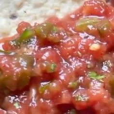 a close up of food on a plate with rice and salsa in the background,