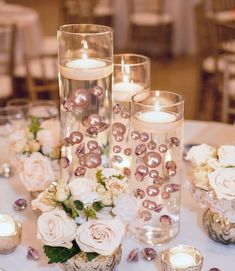 the centerpieces are filled with flowers and candles for an elegant touch to the table