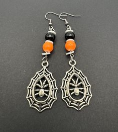 the earrings are decorated with black and orange beads