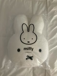 a white stuffed animal with a black bow on it's head in a plastic bag