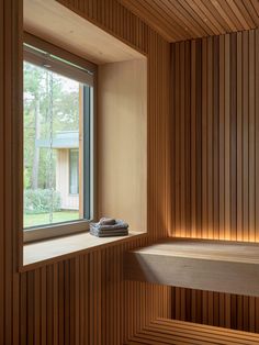 a wooden room with a large window and a bathtub in the corner next to it