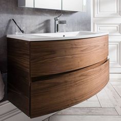 a bathroom sink with a wooden cabinet underneath it