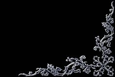 an intricately designed piece of silver wire on a black background with space for text