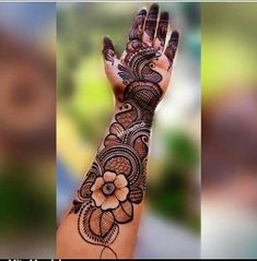 a woman's hand with henna tattoos on it