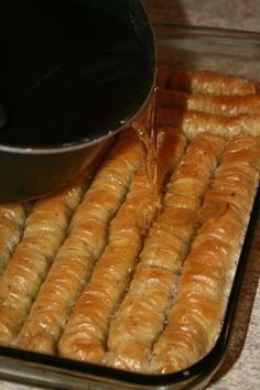 bread sticks being cooked in a pan with water pouring from the top to the bottom