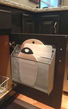 an open dishwasher sitting on top of a wooden floor