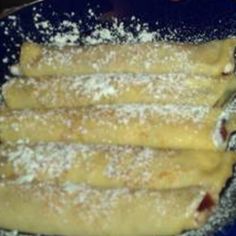 some food is on a blue plate with powdered sugar and sprinkles