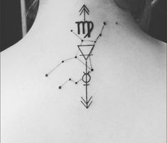 the back of a woman's neck with a zodiac sign and arrows on it