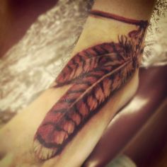 a person with a feather tattoo on their foot