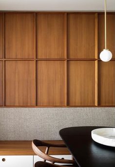 a dining room with wooden paneling on the wall