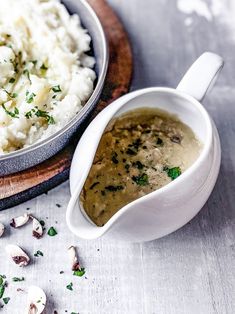 there is a bowl of soup next to a plate of mashed potatoes and mushrooms