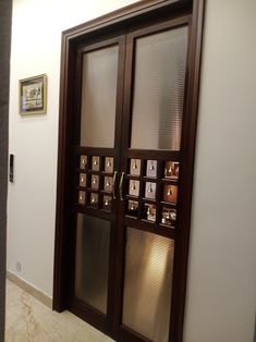 an open door with pictures on it in a room that has white walls and marble floors