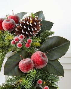 a christmas wreath with berries and pine cones