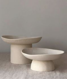 two white bowls sitting on top of each other