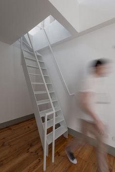 a blurry photo of a man walking down the stairs in front of a white wall