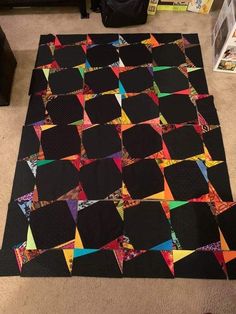 a large black quilt on the floor in a room