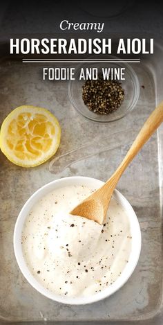 a white bowl filled with food next to a wooden spoon and some lemons on the side