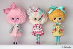 three dolls are lined up on a shelf