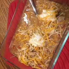 a casserole dish with cheese and meat in it on a red plate next to a fork