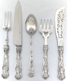 an assortment of silverware including forks, knives and spoons on a white surface