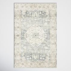 an area rug in grey and white with a medallion design on the center, along with a light gray background