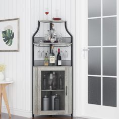 an open cabinet with wine glasses and bottles on the top, in front of a white wall