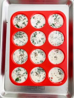 a red tray filled with cupcakes covered in white icing