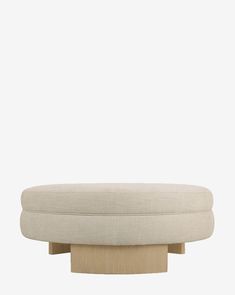 a white ottoman sitting on top of a wooden base