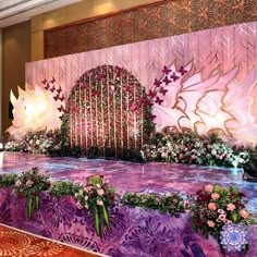 an elaborate stage set up with flowers and butterflies on the wall for a wedding ceremony