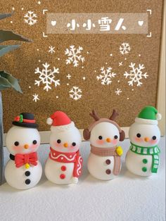 a group of snowmen standing next to each other in front of a wall with snowflakes on it