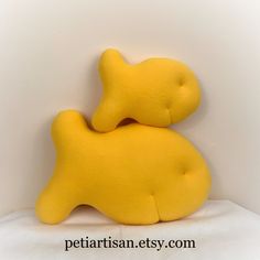 a yellow stuffed animal laying on top of a white sheet