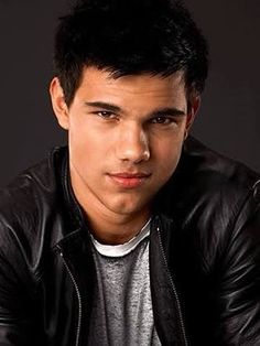 black and white photograph of a young man in leather jacket looking at the camera with serious look on his face